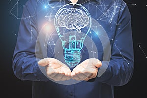 Businessman holding light bulb with brain gologram