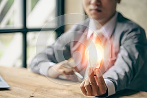 Businessman holding a light bulb, new idea, cutting-edge technology and creativity to save energy