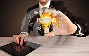 Businessman holding a light bulb, social media concept