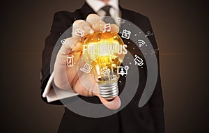 Businessman holding a light bulb, social media concept