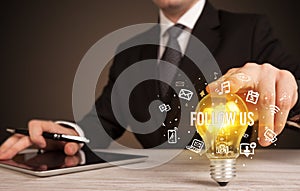 Businessman holding a light bulb, social media concept