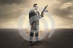 Businessman holding a machine gun