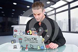 Businessman holding magnifying glass while digital marketing on laptop