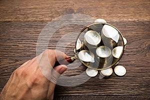 Businessman Holding Magnifying Glass Over Coins