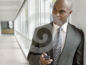 Businessman Holding Mobile Phone In Office