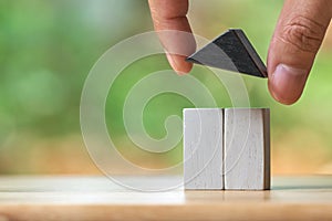 Businessman holding a model house model is placed on a pile of coins.using as background business concept and real estate concept