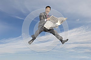 Businessman Holding Newspaper Against Cloudy Sky