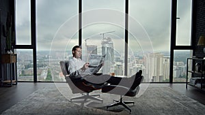 Businessman holding open newspaper in office. Worker reading financial newspaper