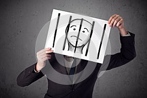 Businessman holding a paper with a prisoner behind the bars on i