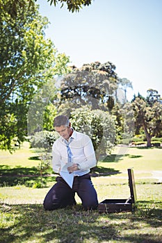 Businessman holding papers in the park