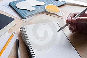 businessman holding pen with notebook working on table