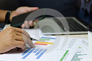 Businessman holding pen to work computer graphs and charts data statistical data financial analysis documents