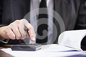 Businessman holding pen while working with document