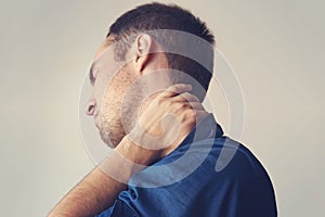 Businessman holding a phone and her neck with pain