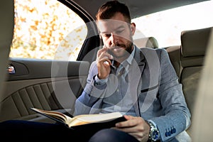 Businessman holding a phone and reading the notes