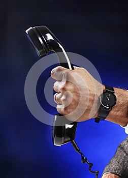 Businessman holding a phone receiver. Conceptual image shot