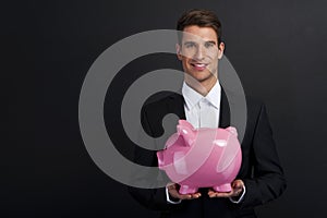 Businessman holding piggy bank