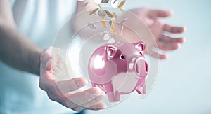 Businessman holding piggy bank with flying coins going inside 3D rendering