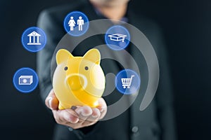 Businessman holding piggy bank with icons of planning family life, insurance