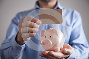 Businessman holding piggy bank. Savings money