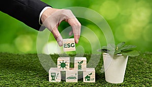 Businessman holding plant pot with ECO cube symbol. Alter