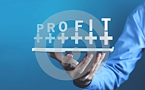 Businessman holding Profit word with a plus symbols