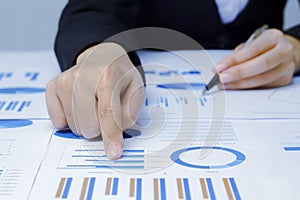 Businessman holding a profitability statistics analysis pen from a graph document in hand  to plan profit