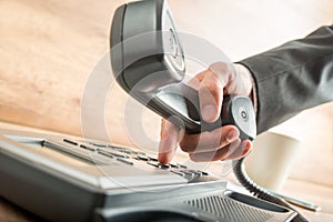 Businessman holding the receiver while dialing