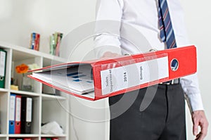Businessman holding a red binder