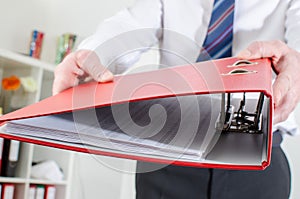 Businessman holding a red binder