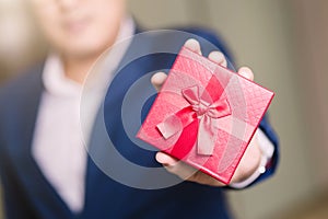 Businessman holding the red gift box