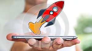 Businessman holding red hand drawn rocket over his mobile phone