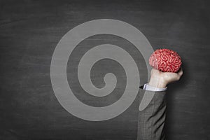 Businessman holding red toy brains photo