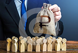A businessman is holding a russian ruble money bag over a crowd of people figurines. Staff maintenance, tax collection, provide