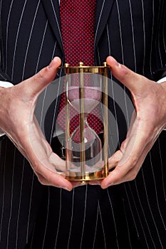 Businessman holding a sand timer