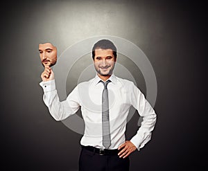 Businessman holding serious mask