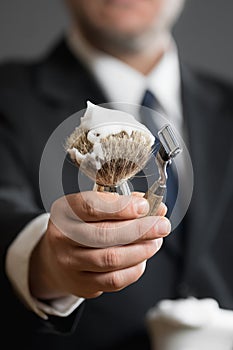 Businessman is holding Shaving Equipment in his Hands