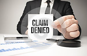 Businessman holding sheet of paper with a message Claim Denied