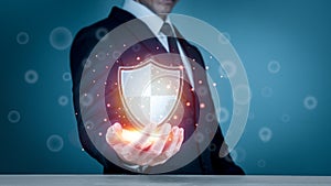 Businessman holding shield protect icon for internet firewall, insurance, or computer virus cleaner. Concept cyber security safe