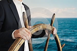 Businessman holding ship rudder and navigates photo