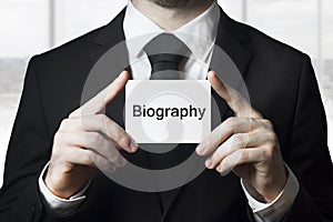 Businessman holding sign biography photo