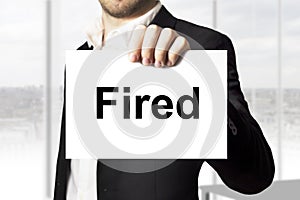 Businessman holding sign fired