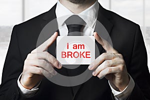 Businessman holding sign i am broke