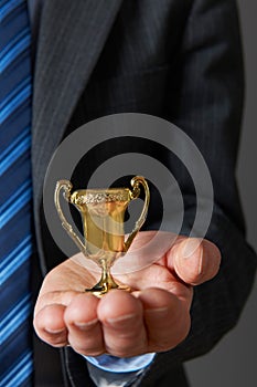 Businessman Holding Small Trophy