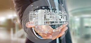 Businessman holding a Smart building connected - 3d rendering