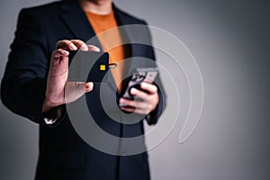 Businessman holding a smart card reader and smartphone, demonstrating secure digital authentication technology for financial