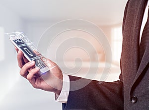 Businessman holding smart phone with media icons.