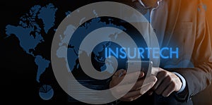 Businessman holding a smartphone with inscription word INSURTECH.background at night,concept futuristic Business, Technology,