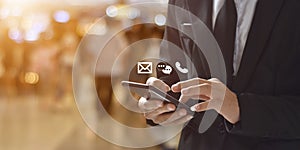 Businessman holding smartphone with message, calling, email icon.