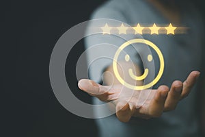 Businessman holding smile icon and five stars, service and customer satisfaction concept